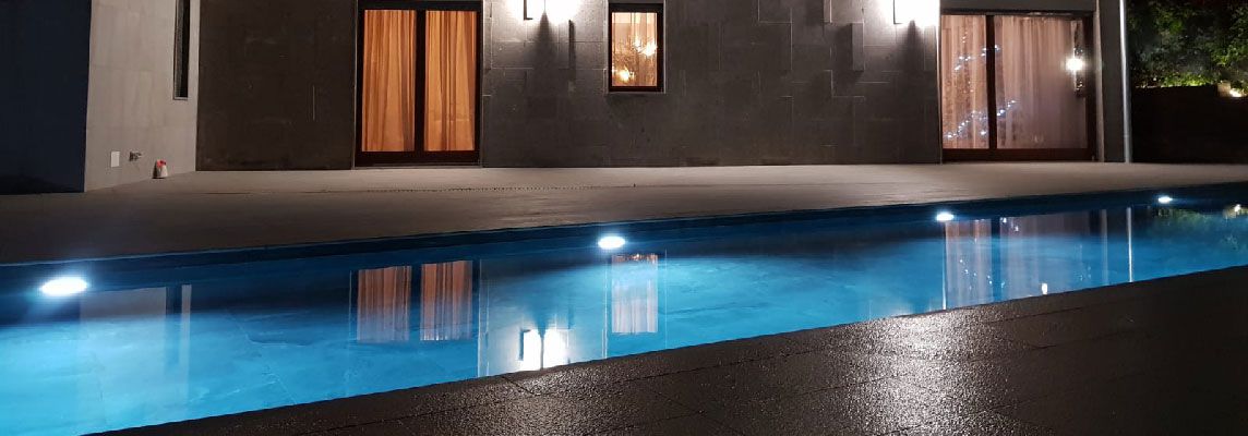 Swimmingpool in Formello: Licht-Schatten-Spiele durch Feinsteinzeug in Steinoptik